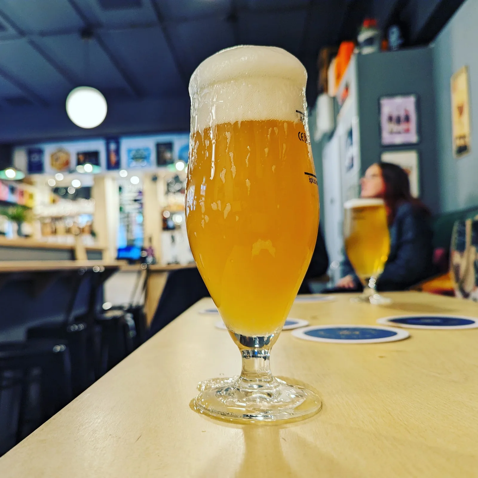 A golden pint in the softly lit interior of The Curious Hop