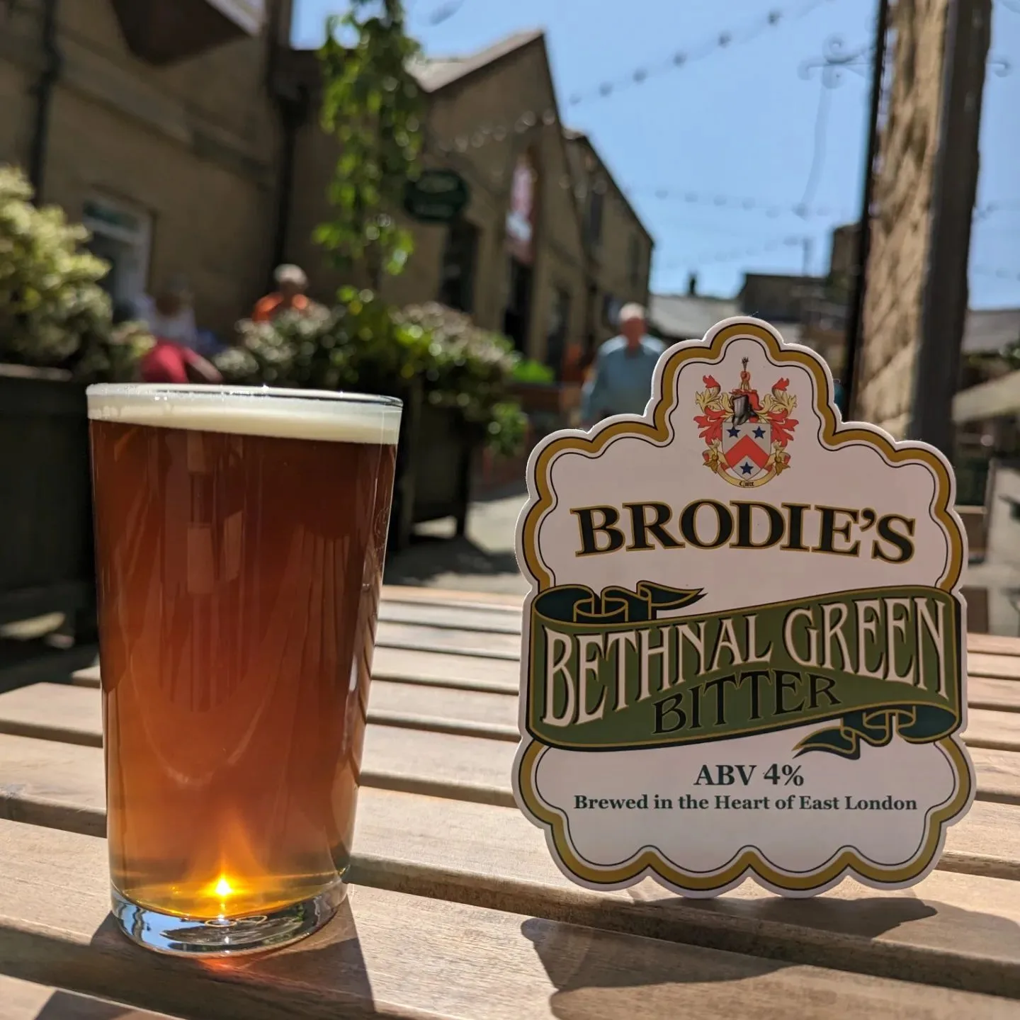 A pint of bitter on a sunny courtyard table at The Curious Hop