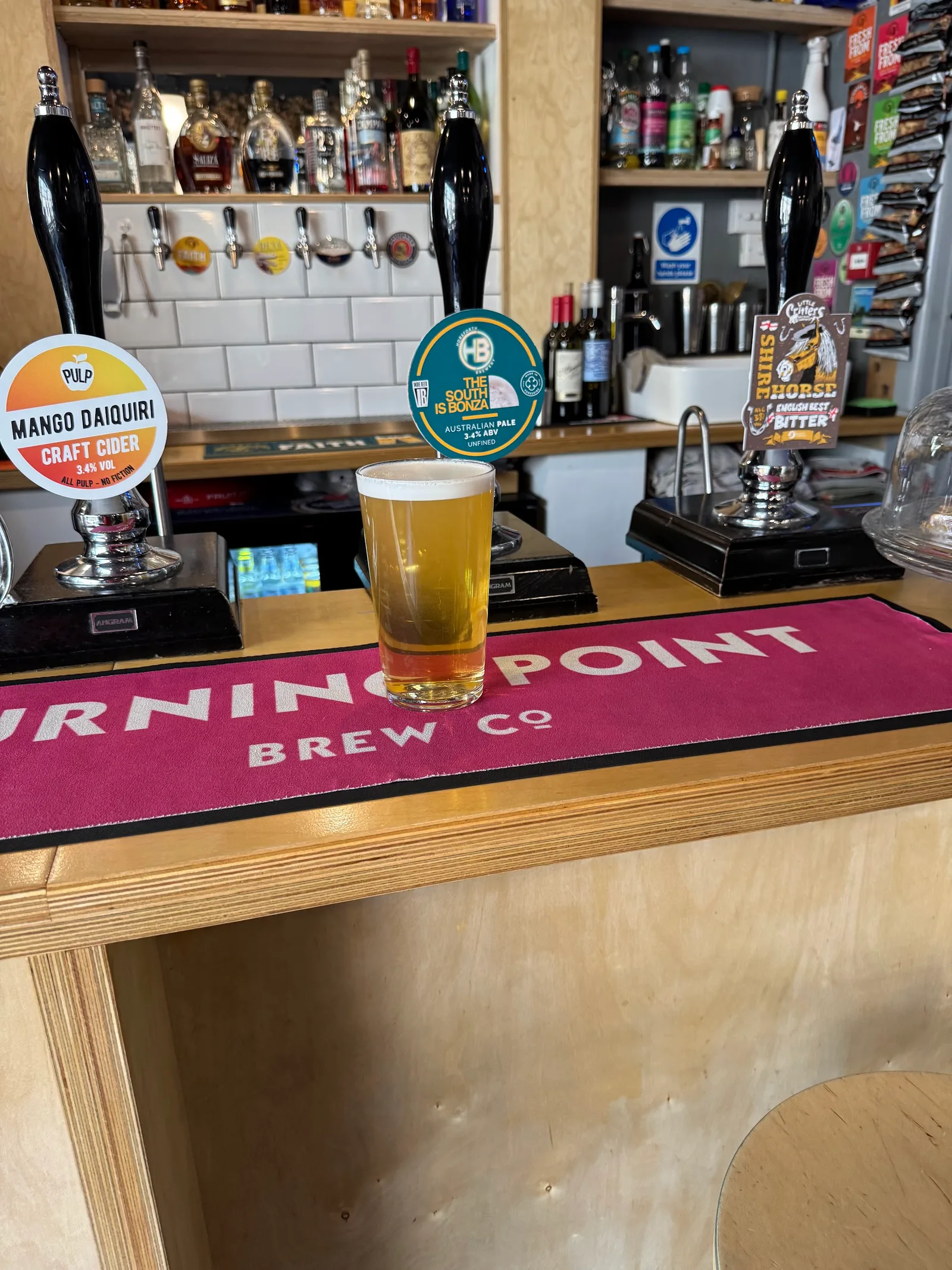 A pint on the bar beside the cask handpumps at The Curious Hop
